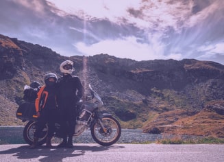 two-people-standing-by-a-motorbike